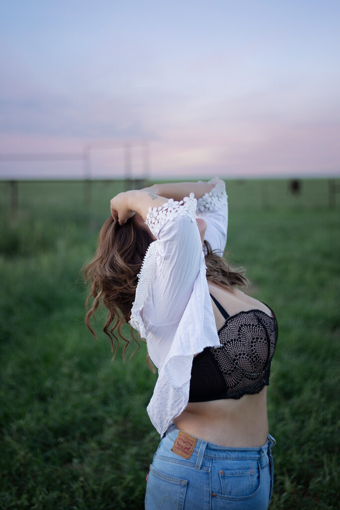 Boudoir session outside with green grass and beautiful West Texas sunset