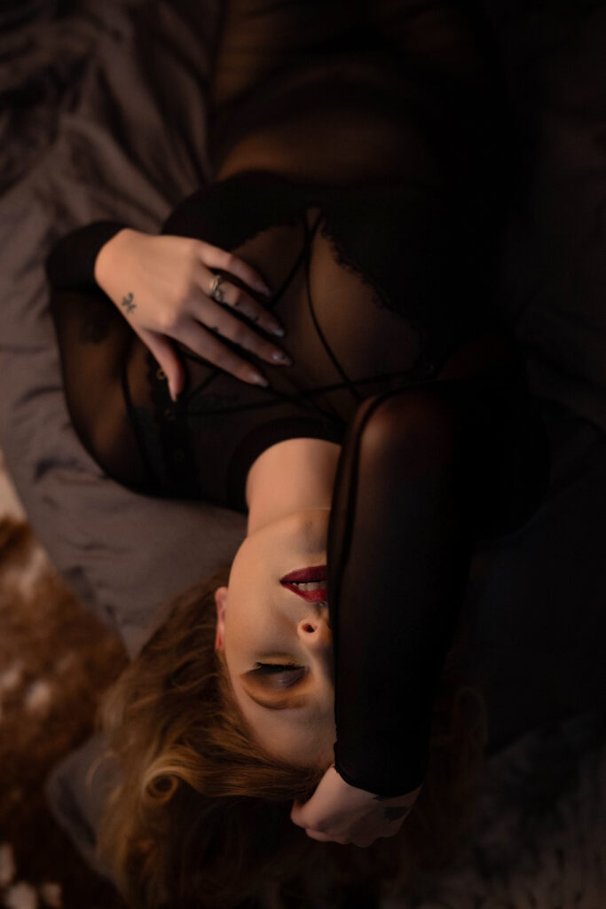 Jara lying back with her hand resting on her forehead during her Halloween boudoir session in Tulia, Texas.
