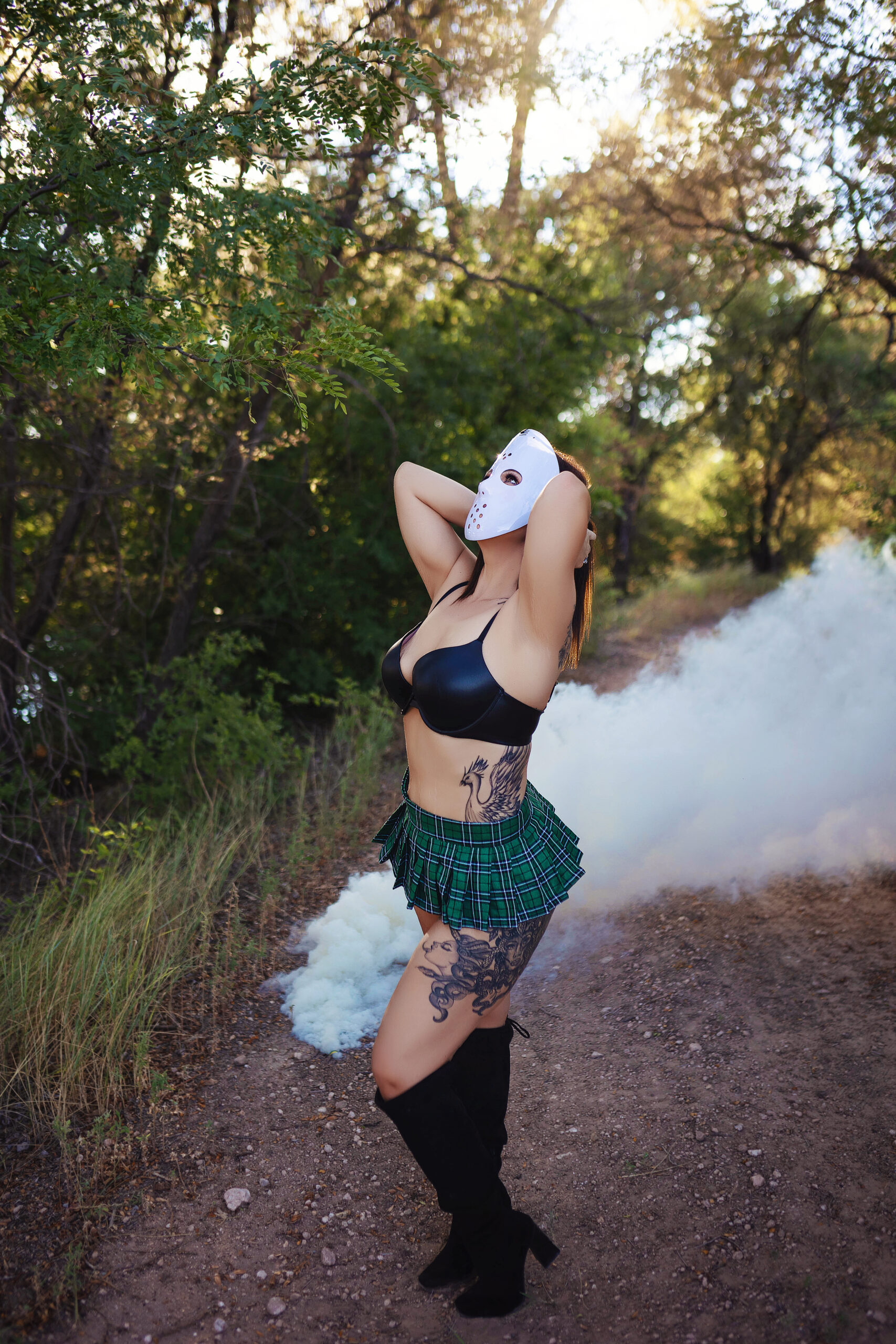 Woman wearing a mask with a black bra and green plaid skirt, posing confidently with a smoke effect during a Halloween boudoir session in Tulia, Texas.