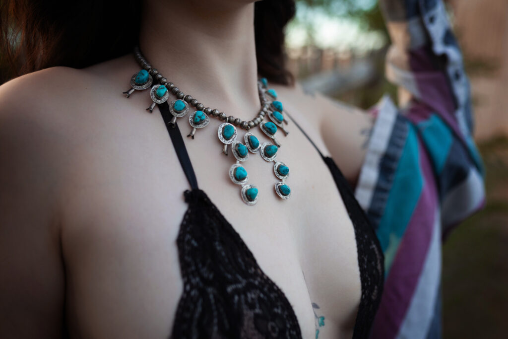 Close-up of Thalia’s turquoise necklace in a Western-inspired boudoir session.